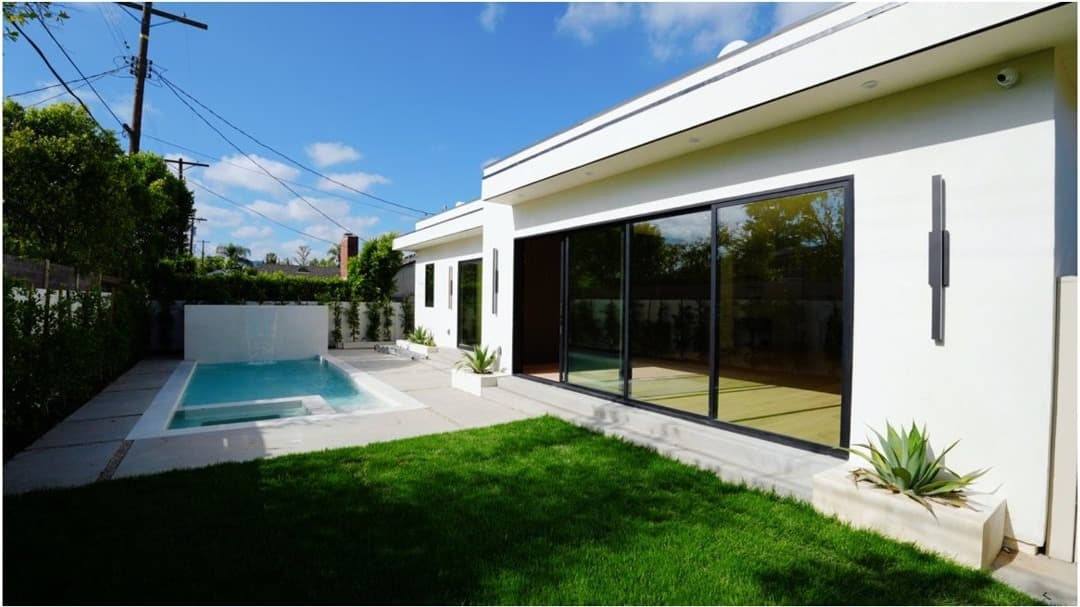 Completed modern home exterior with pool and lawn